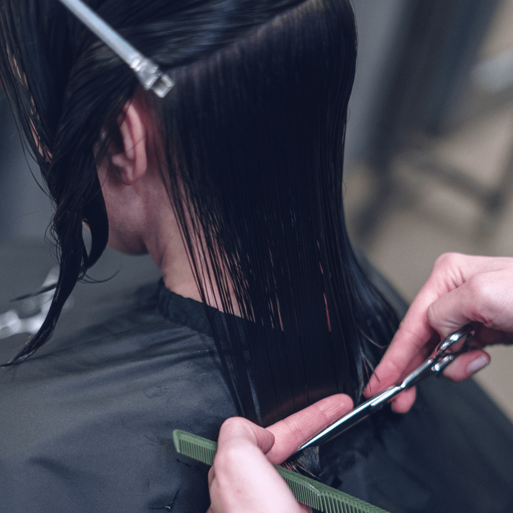 short hair cut style hair is sectioned with hair clips combed down straight mobile hairdresser is giving haircut