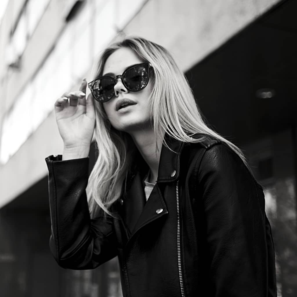 blonde hair highlight with root smudge model wearing sunglasses and leather coat