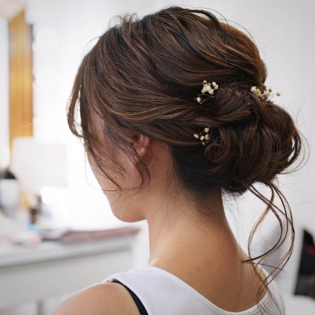 low bun wedding hair updo back view of brunette hair bride styled for engagement shoot hair