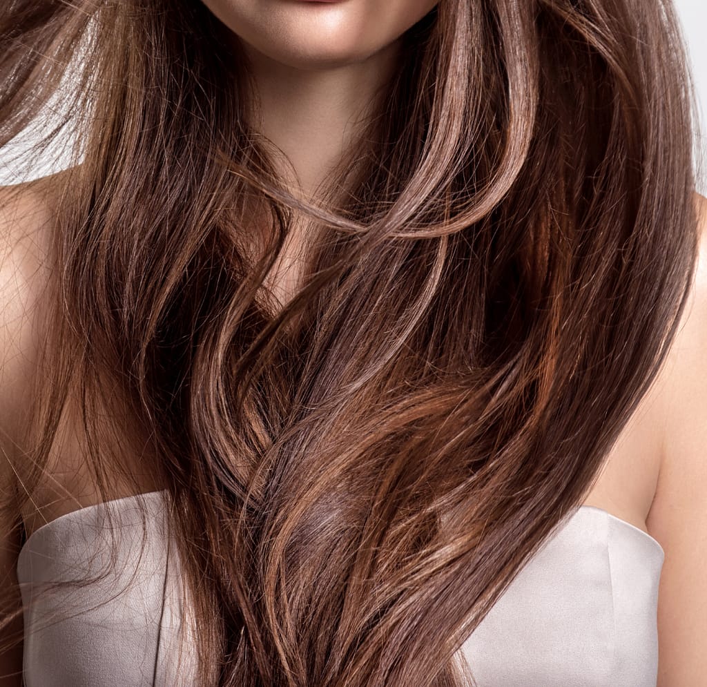 close-up photo of long hand tied weft hair extensions brunette sandy color