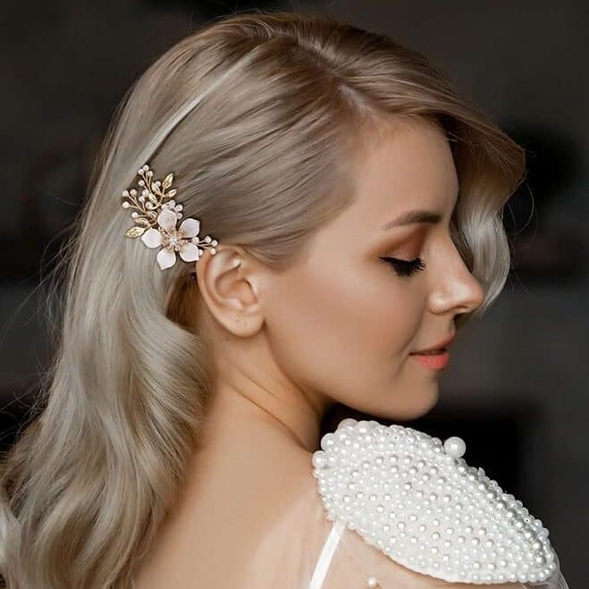 side view of blonde hair bride smiling with a delicate floral hair pin wedding hair accessory